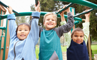 Three Young Boys On Climbing Frame In Playground