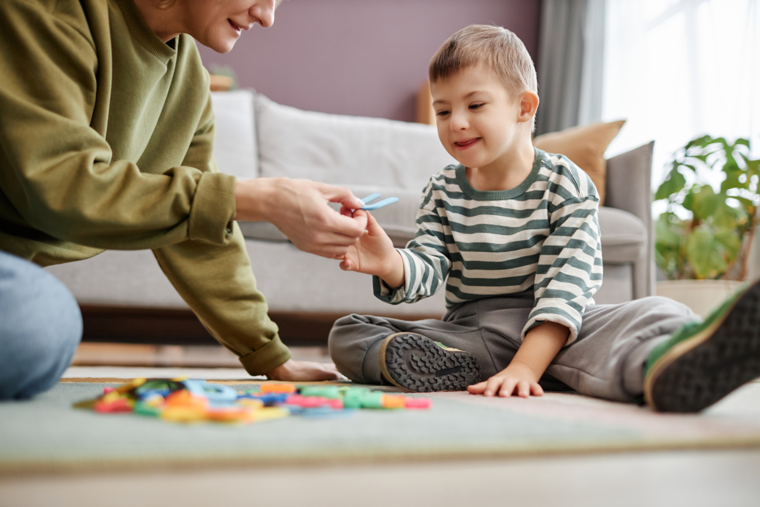 Happy Little Boy With Down Syndrome Playing With Letters On Floor