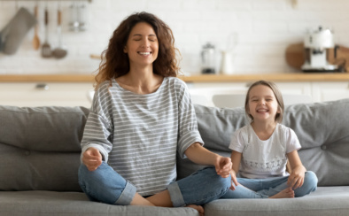 Happy Young Nanny Mom Teaching Small Daughter Yoga Breathing Exercise.